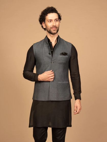 A Western-style Nehru jacket in a grey textured fabric, layered over a black kurta. This look combines timeless sophistication with modern elegance, making it a versatile choice for formal events where you want to make a stylish statement.