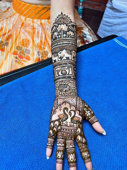 A full-arm design for an NRI bride, featuring swans, elephants, and traditional Indian motifs.