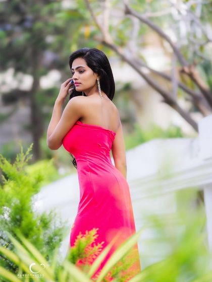 A beautiful portrait set amongst green foliage. The soft, natural light and her gentle expression create a serene and timeless feel.