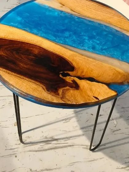 This simple yet elegant river table uses a beautiful blue resin pour to complement the natural grain of the wood. The hairpin legs give it a modern, industrial feel.