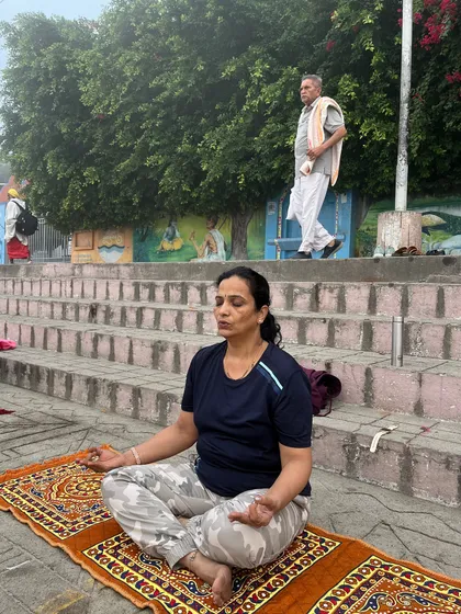 A participant finds her inner stillness while meditating on the banks of the Ganges.