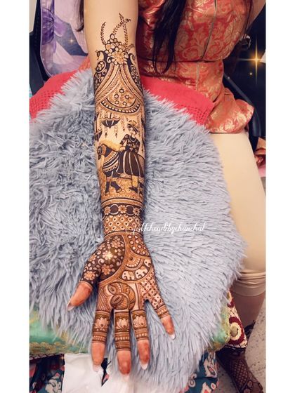 This full-arm bridal mehendi features a romantic scene of the couple under a decorated umbrella. The design is filled with elephants and floral patterns, creating a rich and celebratory look.