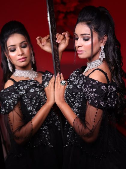 The smoky eye makeup and diamond jewelry perfectly complement the drama of this black embroidered ball gown. A look fit for a modern queen.