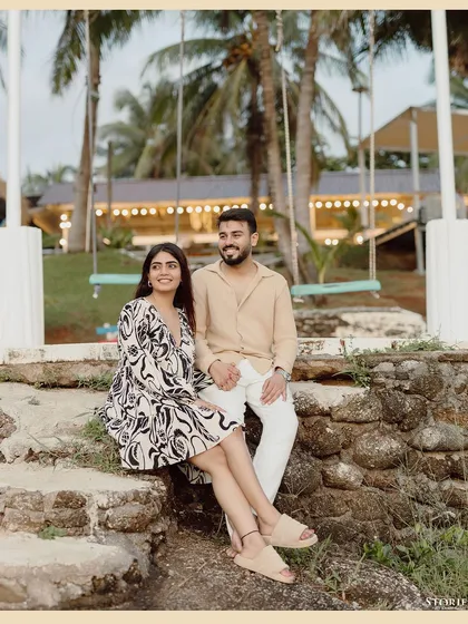 A sweet portrait of the couple seated in a tropical setting.