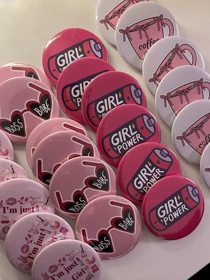 A collection of the fun and colorful badges included in our Women's Day gifts, with themes like "Girl Power," "Boss Babe," and "Coffee Girlie."