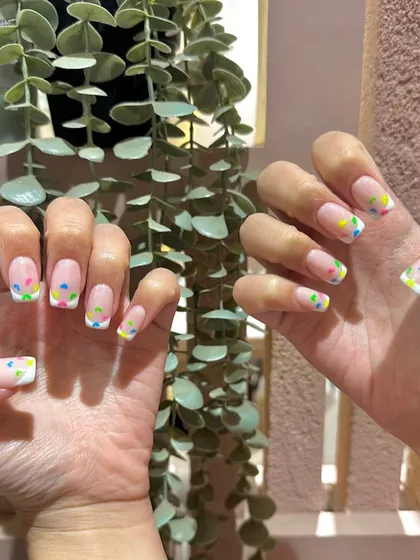 A party on your nails! This fun French manicure features colorful confetti-style dots on the tips for a festive and joyful look.