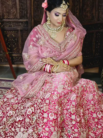 A stunning pink and red velvet lehenga with dense floral embroidery. This is a heavy, premium piece perfect for a winter wedding.