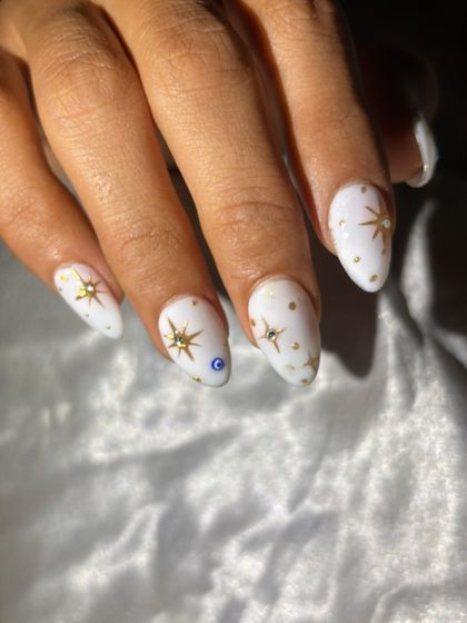 A celestial-themed design on a solid white base, with hand-painted gold stars and a protective evil eye accent.