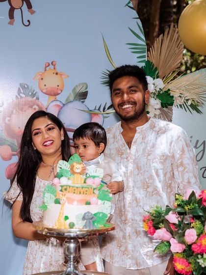 Another happy family moment at Chaiyan's jungle-themed first birthday. The custom-designed backdrops and themed cake bring the whole safari concept together beautifully.