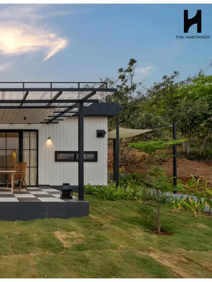 This angle highlights the home's connection to the outdoors, with a covered patio area and sail shade providing comfortable spaces for relaxation. The design is perfect for a weekend retreat.