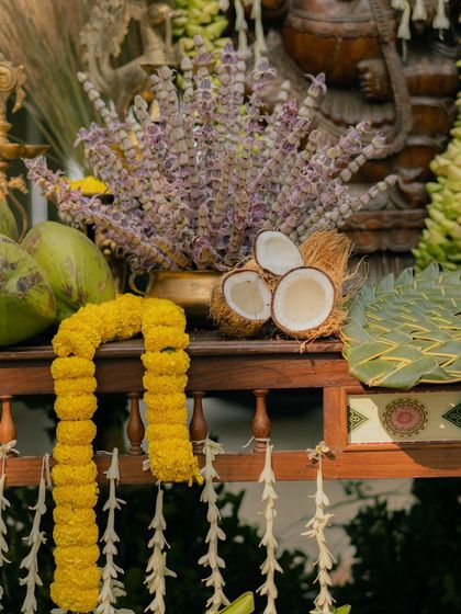 A close up of the offerings, showing a marigold garland, fresh coconuts, and fragrant tulsi. Every element is chosen for its cultural significance and aesthetic appeal.