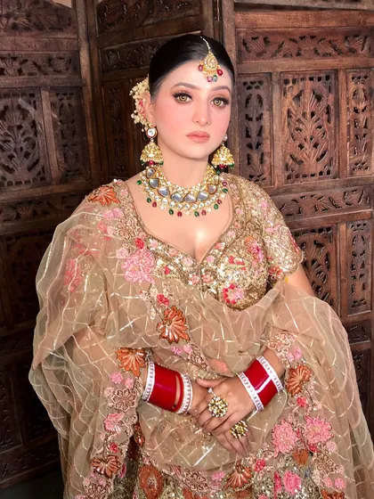 A full view of the bride, looking regal and elegant in her gold ensemble.