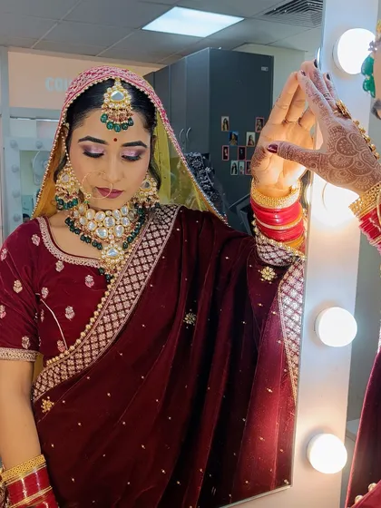 The bride admiring her reflection, a moment of confidence that our students strive to create with their artistry.