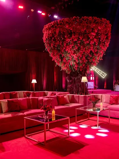 A towering tree made entirely of red roses served as a stunning focal point and photo opportunity. It was surrounded by plush, modern lounge seating, creating a dramatic yet comfortable space for guests to gather.