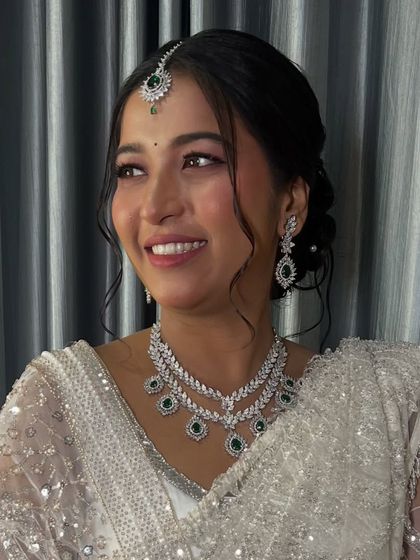 A timeless look in a white saree, perfect for a reception or engagement. The makeup is soft and ethereal.