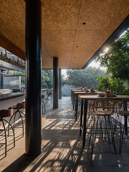 The outdoor bar at Zero40 Brewery, featuring high-top tables and stools with a view of the garden. The design blends an industrial pub feel with the natural, relaxed vibe of the surrounding landscape.