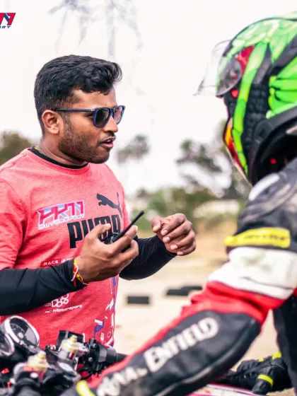 On-track communication is key. A coach uses a radio to give real-time feedback to a rider during a session, helping them make immediate adjustments and accelerate their learning curve.