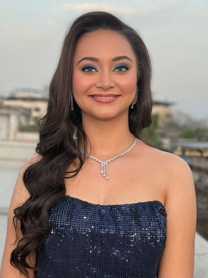 A beautiful smile to complete the look. The soft blue eyeshadow makes her eyes pop, while the glossy lip and dewy skin keep the look fresh and modern.