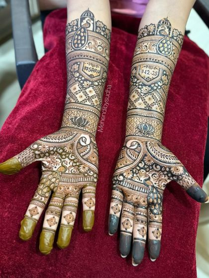 A clear, top-down shot of the engagement mehendi with the '#SARU' hashtag and special date.