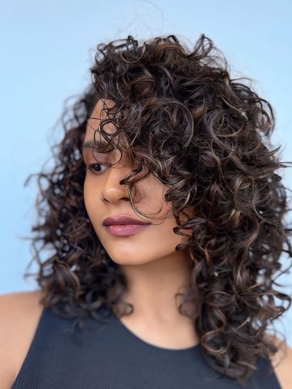 Espresso-toned curls with a beautiful natural bounce. This look was achieved with a custom cut and color to enhance the client's curl pattern.