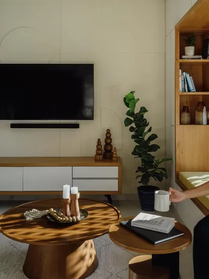 Another view of the living area, showing how the custom coffee tables and TV unit work together in the space. The warm wood tones bring a natural element into the modern room.