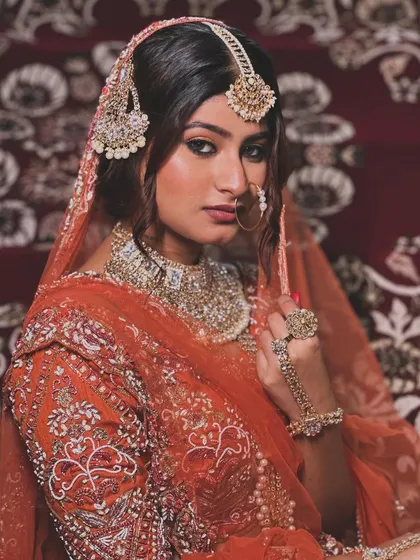 A powerful and direct pose, showcasing the intricate jewelry and makeup.