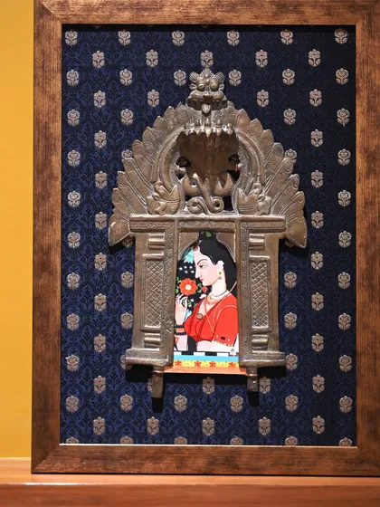 The smaller of the two custom Prabhavali frames. This piece features a lady from a Mughal miniature, framed against a deep blue Banarasi silk with a silver zari buta pattern.