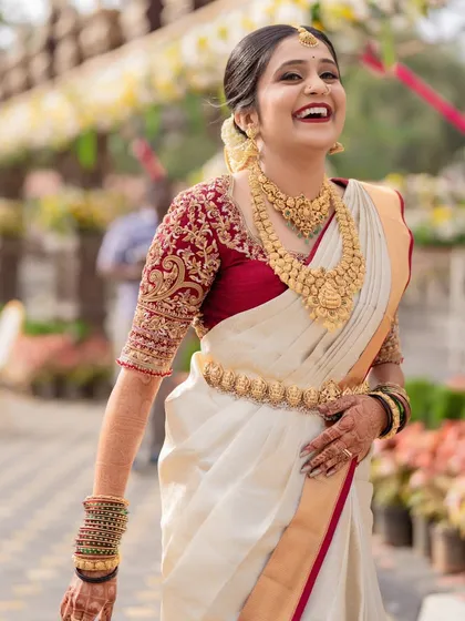 Capturing pure, unscripted happiness. This bride's radiant smile says it all. Her traditional muhurtham makeup features a warm, glowing base and a classic red lip, designed to look stunning both in person and in photos.