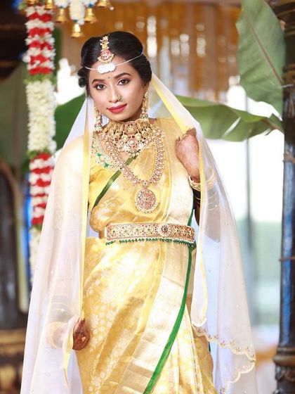 Our bride Aisha looks stunning in a golden Kanjeevaram saree, perfectly complemented by our layered temple jewellery set and a traditional matha patti.