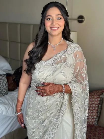 A full-length view of her elegant white saree. The soft glam makeup is the perfect complement to her sophisticated Roka outfit.