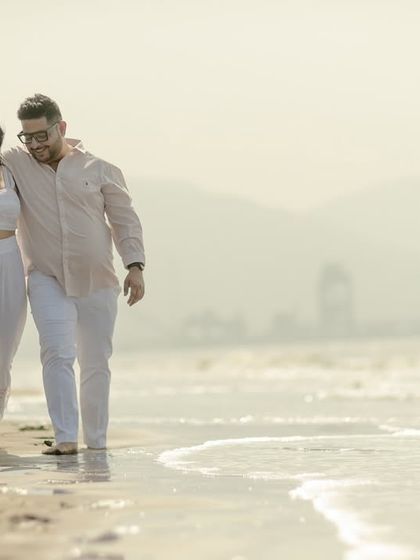 A candid photo of a couple walking along the shoreline, lost in their own world. These are the real, unscripted moments I aim to capture.