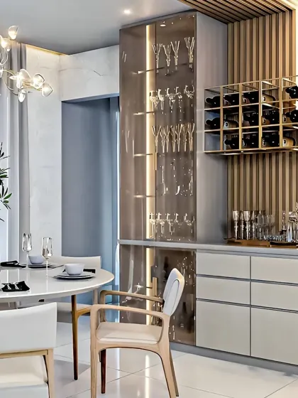 We created this elegant dining area with a dedicated bar and crockery unit. The design features a tall, back-lit glass cabinet for showcasing glassware, a custom wine rack, and sleek drawers for storage, all integrated into a stylish, modern setup.