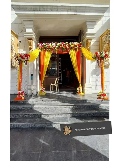 A classic and auspicious entrance decoration for a home wedding. I use bright yellow and orange drapes combined with fresh flower arrangements to create a warm and traditional welcome.