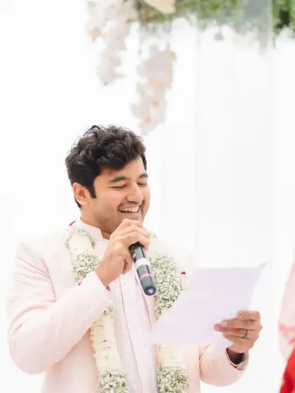 The groom's turn to read his vows, his face lit up with a smile. This candid shot captures his joy and the emotional depth of their personalized ceremony.
