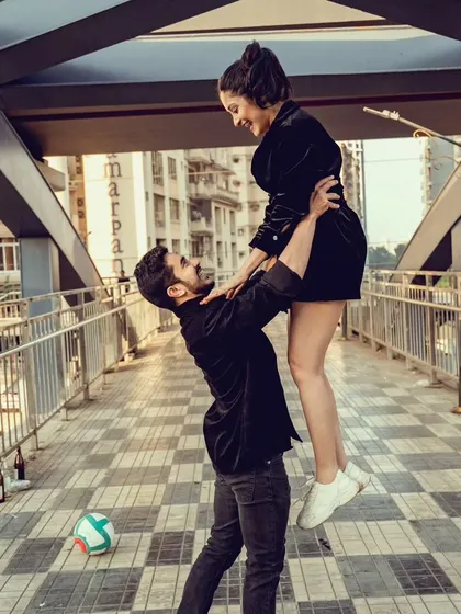 A playful and energetic lift on a city bridge, full of laughter and movement. This photo captures the fun-loving dynamic of the couple during their Mumbai pre-wedding shoot.