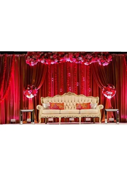 For those who love bold and dramatic themes, we design vibrant stage decor like this. The rich red draping, floral arch, and elegant seating come together to create a luxurious and royal backdrop for a wedding or reception.