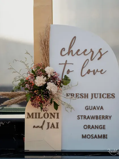 A chic and modern sign for the juice bar, decorated with pampas grass and delicate flowers.