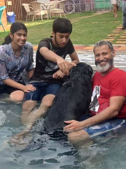 A father and his kids sharing a special moment with their black lab in the pool. These are the memories we love to help create.