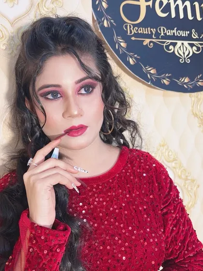 A close-up of the glamorous red dress look, focusing on the dramatic eye makeup and the perfectly styled curls.