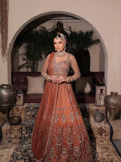 The full picture of a modern maharani. This rust-toned bridal outfit is paired with makeup that is both regal and contemporary, perfect for the bride who walks her own path.