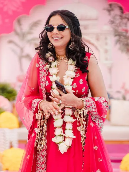 The perfect Haldi vibe! Shilpi's carnival look was modern and fun. Since she wore sunglasses for much of the event, we kept her eye makeup muted and let her radiant skin and stunning pink lehenga steal the show.
