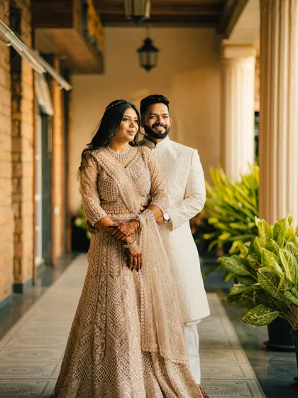 A classic portrait of a couple standing together, looking out towards the light. This image is elegant, poised, and beautifully composed.