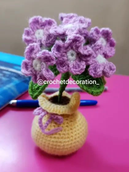 A lovely bunch of purple phlox flowers in a cheerful yellow pot. This delicate arrangement is perfect for decorating a desk or work table.