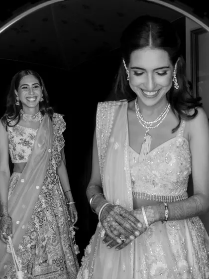 Sisters Karna and Gayatri share a smile before the sangeet. This black and white portrait captures their close bond and the shared excitement of the wedding festivities.
