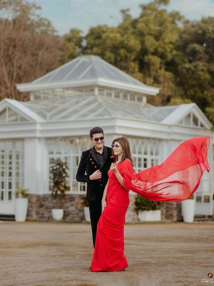 A dramatic, wide shot from the 25th-anniversary shoot. The makeup ensures her features are defined and she stands out beautifully against the grand backdrop.
