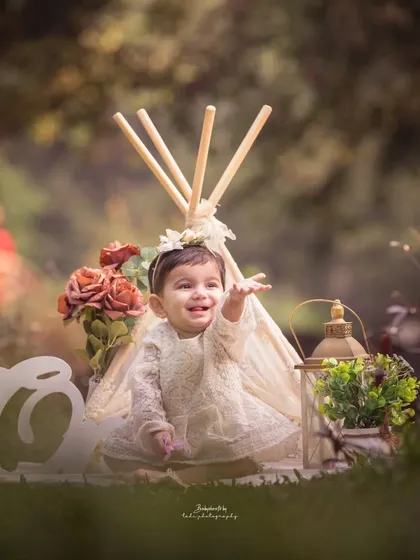 Reaching out with a smile. This outdoor boho-themed shoot captures the birthday girl's curious and happy nature.