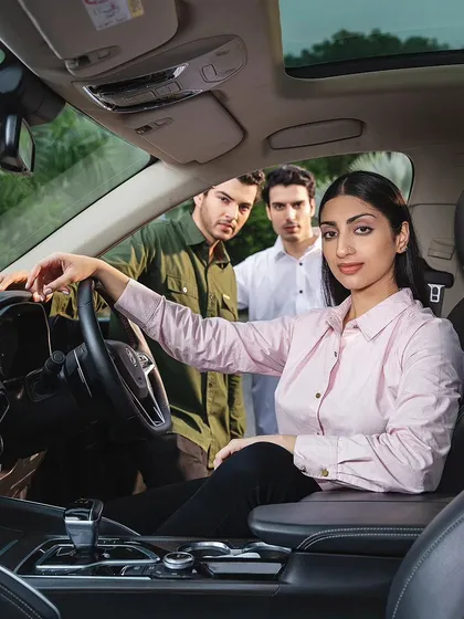 An in-car lifestyle scene from the MG Motor campaign. This image tells a story, placing the branded apparel within an aspirational context of travel and modern living.