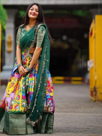 I love the blend of tradition and art in this Kalamkari-style Langa Davani. The vibrant, multi-colored skirt paired with a deep green blouse makes it a unique and eye-catching choice for festive events or cultural celebrations.