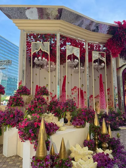 A decor corner where traditional golden elements are surrounded by a profusion of bold, colorful blooms. The mirrored panels add a touch of modern glamour.