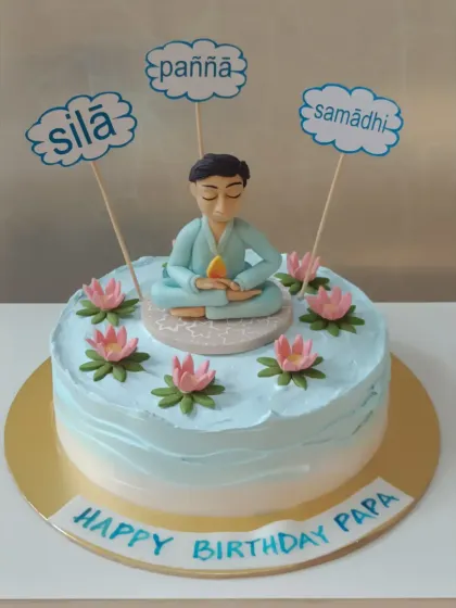 A serene cake for a spiritual person. This design features a meditating figure and signs representing the Buddhist principles of Sila, Samadhi, and Panna.